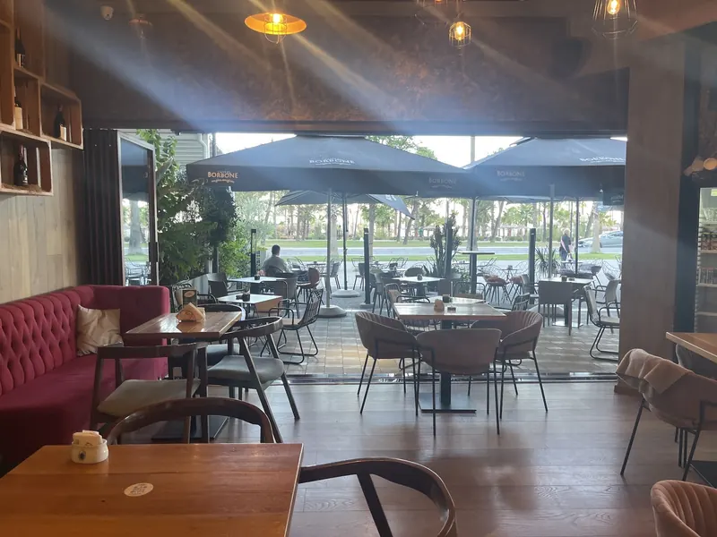 The Likaj café opening onto its Lungomare terrace, with sunlight and palm trees outside