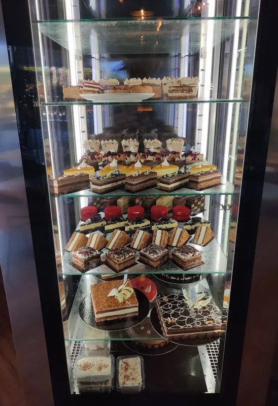 A glass cabinet of layered cakes and pastries